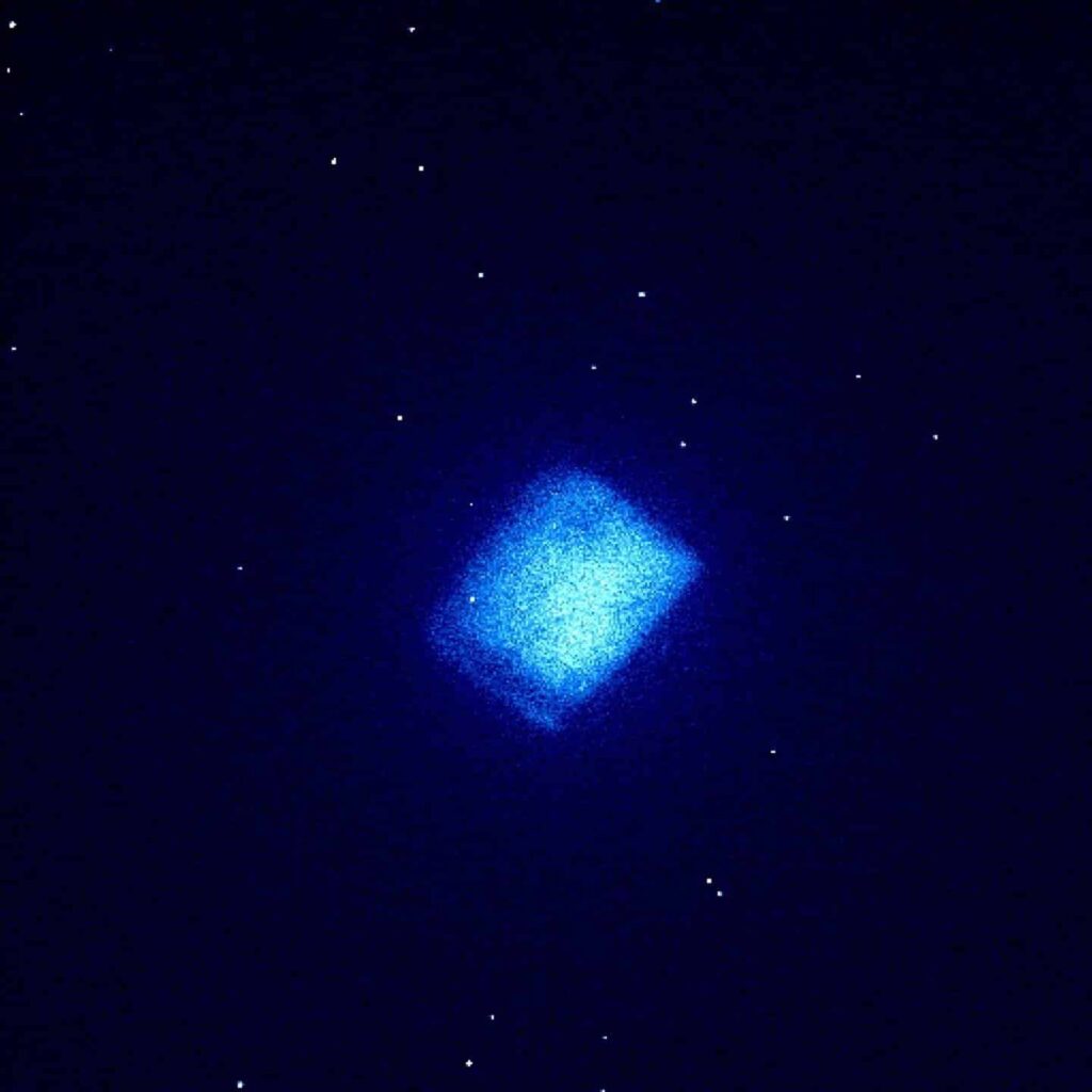 A blue glowing battery in the dark.