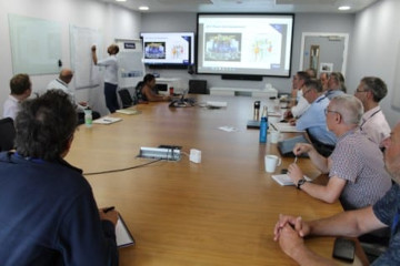 People in a meeting room watch a presentation.