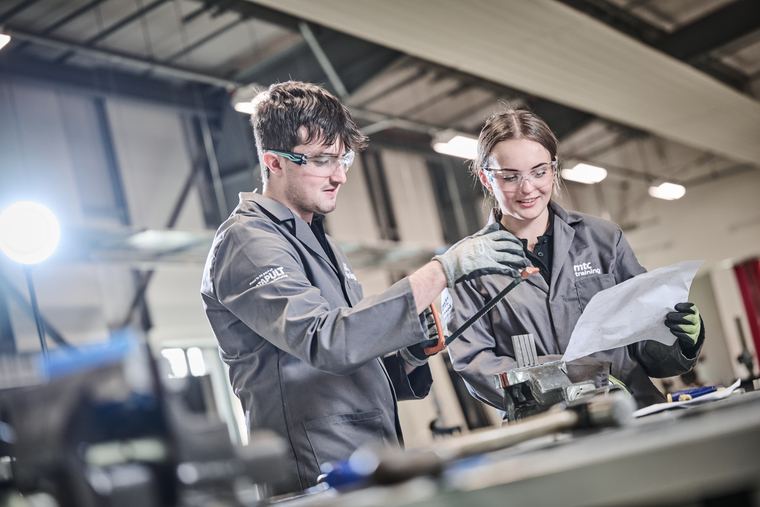 people in protective clothing handling tools in a workshop