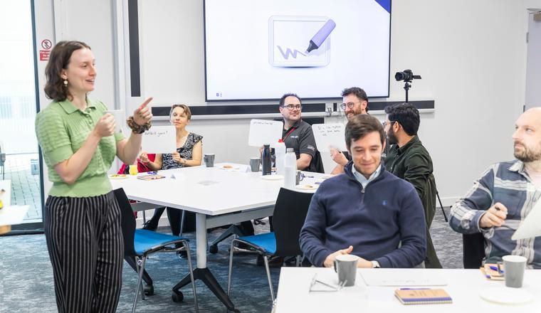 An expert giving a lesson on tritium for the Tritium Training Course in a classroom at UKAEA's Culham Campus.