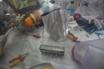 An expert operator working in a laboratory wearing protective clothing.