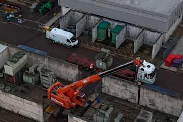An aerial shot of a building site with cranes and trucks in action.