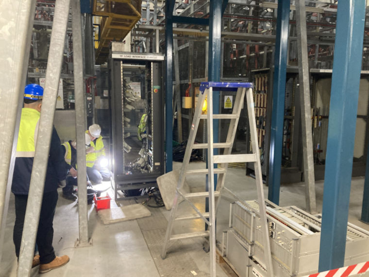 Specialists inside an industrial building dismantling some equipment.