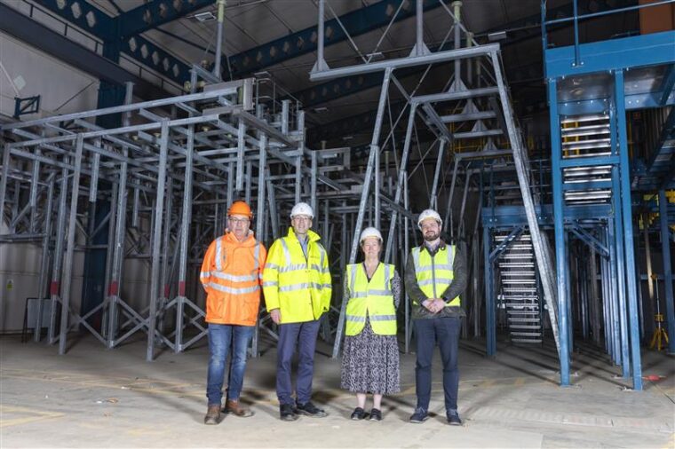 Experts in high visibility clothes in a large industrial building.