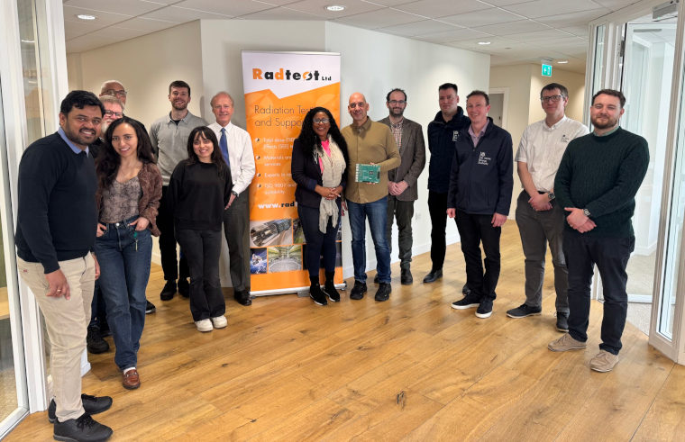 A team of experts standing in front of a Radtest Ltd poster.