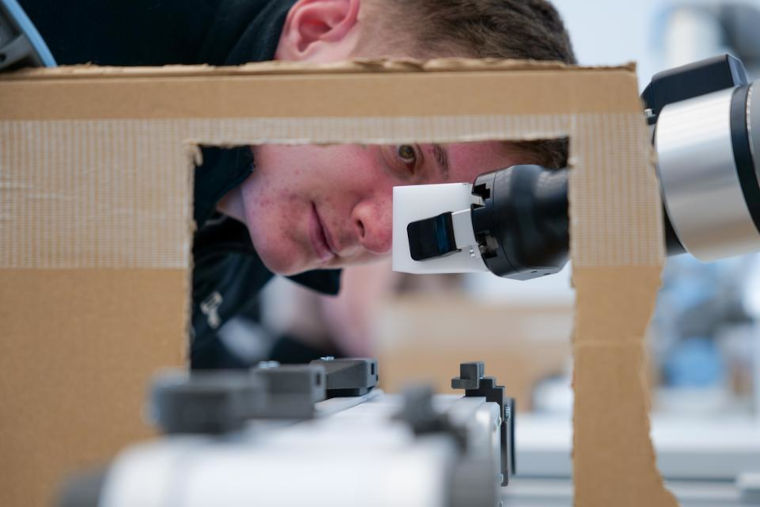 An expert looking closely at a robotics experiment at UKAEA.