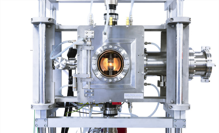 A complex metal machine with a lens in the centre.