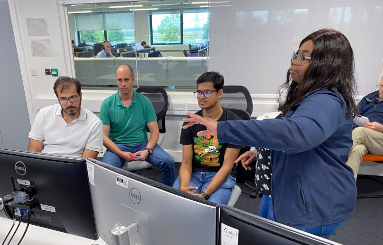 Trainer demonstrating remote operation techniques to participants during a training session in the control room at RACE.