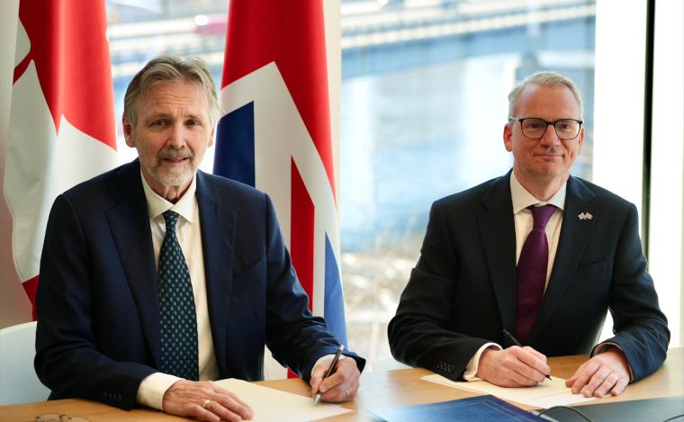 Dr. Spencer Pitcher, Co-founder and CEO of Stellarex Energy, and Stephen Wheeler, UKAEA Executive Director signing an agreement infront of the flags of Canada and the United Kingdom.