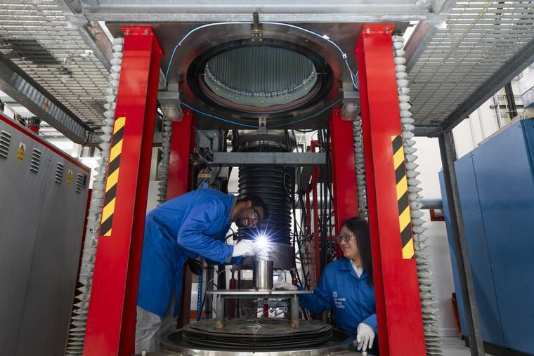 Two specialists joining technologists wearing UK Atomic Energy Authority lab coats carry out some brazing. 