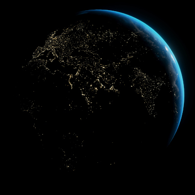 A view of the Earth from space showing the blue glow of dawn on the sea and glowing city lights in the shadow of the night.