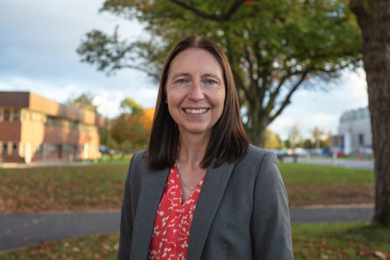 Doctor Kirsty Hewitson on a campus with trees.
