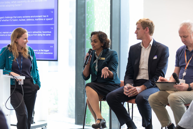 A panel of 4 experts speaking in front of an audience.